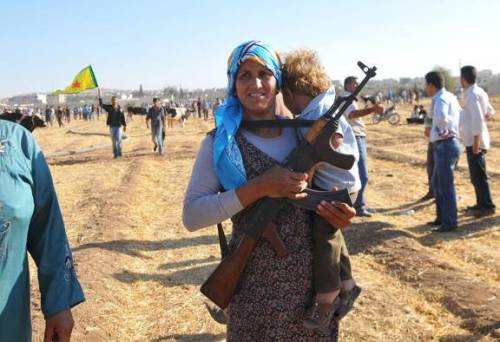 زن کرد سوری و فرزندش در مرز سوریه و ترکیه (رویترز)