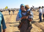زن کرد سوری و فرزندش در مرز سوریه و ترکیه (رویترز)