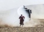 زن سوری در جریان درگیری با نیروهای ترک در مرز از ماشین های آب پاش می گریزد(گتی ایمیجز)