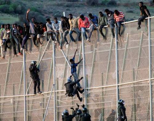 تلاش مهاجرین آفریقایی برای عبور از سیم های خاردار مرز مراکش و اسپانیا و درگیری با پلیس مرزی (رویترز)